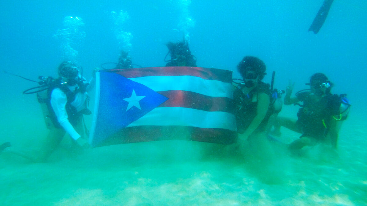 Bandera de Puerto Rico debajo del agua en la playa Crash Boat en Aguadilla