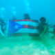 Bandera de Puerto Rico debajo del agua en la playa Crash Boat en Aguadilla