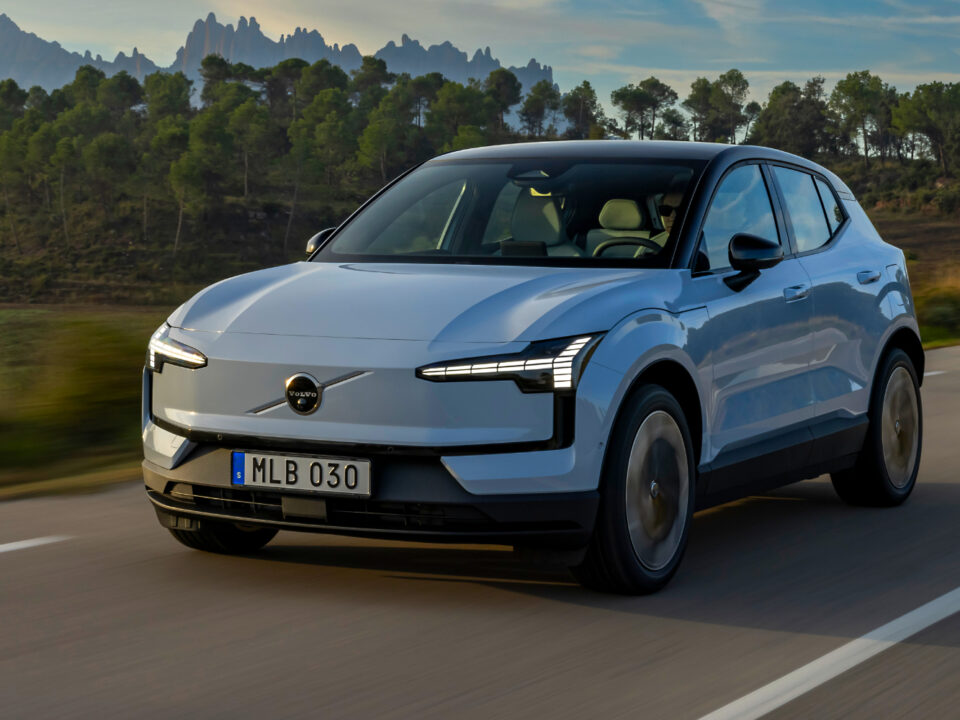 vista delantera del volvo ex30 corriendo en zona rural con montañas en el fondo