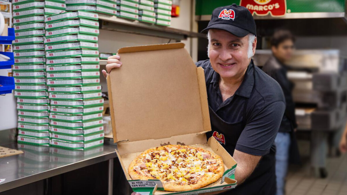 James Lynn presenta su recién hecha pizza hawaiiana de Marco's Pizza